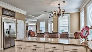 A spacious kitchen with a large island, white cabinetry, and a stainless steel refrigerator. - Bird of Paradise, see the # of 5-stars-Just steps from Beach (Miramar Beach)