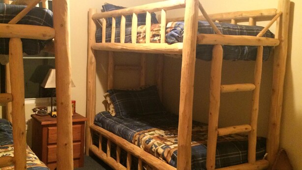 A bunk bed room with a wooden ladder, a desk with a lamp, and a small shelf. - In The Heart Of The Hiawatha National Forest ~ Easy Access To The Trail System (Shingleton)