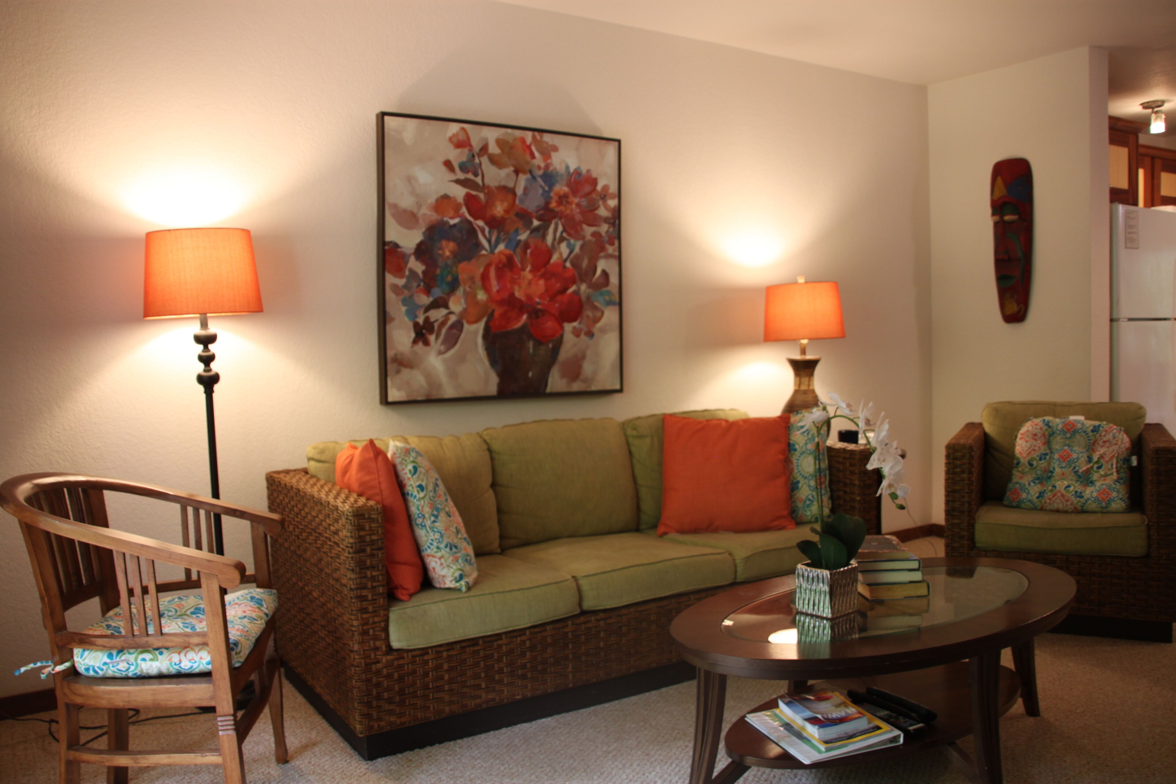 A living room with a sofa, two chairs, a coffee table, and two lamps.