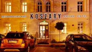 The exterior of the Koszary Arche Hotel with a sign indicating a restaurant and bar. - Koszary Arche Hotel (Gora Kalwaria)