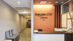 A reception desk with a sign reading "Rakuten Stay Urban Nijo-jo" and a computer setup. - Rakuten STAY URBAN Nijo-jo (Kyoto)