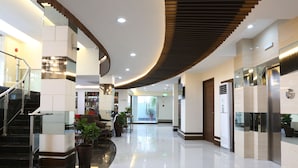 A modern lobby with a curved ceiling, a staircase, and a reception area.