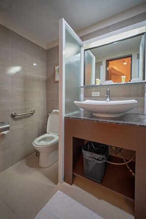 A modern bathroom with a toilet, sink, and mirror. - Achievers Airport Hotel (Pasay)