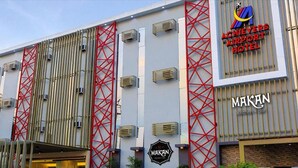 A modern building with a red lattice structure, the Makan restaurant, and the Achievers Airport Hotel sign.