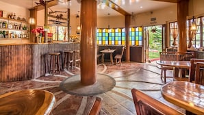 Un espace bar avec des meubles en bois, une colonne centrale et un vitrail.