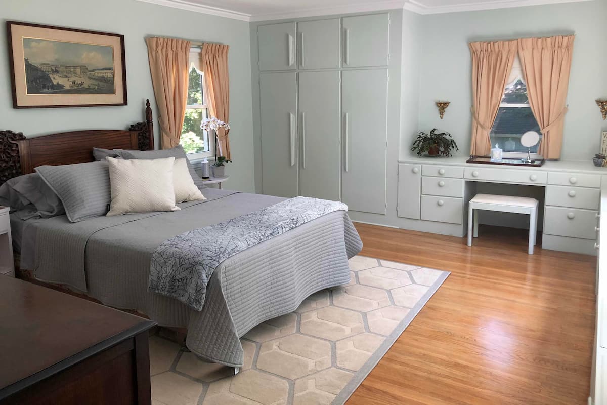 A bedroom with a bed, a desk, a chair, and a wardrobe.