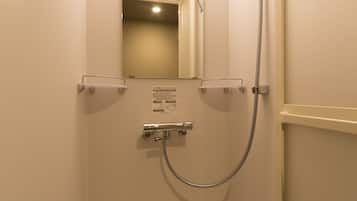 A small, enclosed shower stall with a handheld showerhead, a wall-mounted mirror, and a ceiling light.