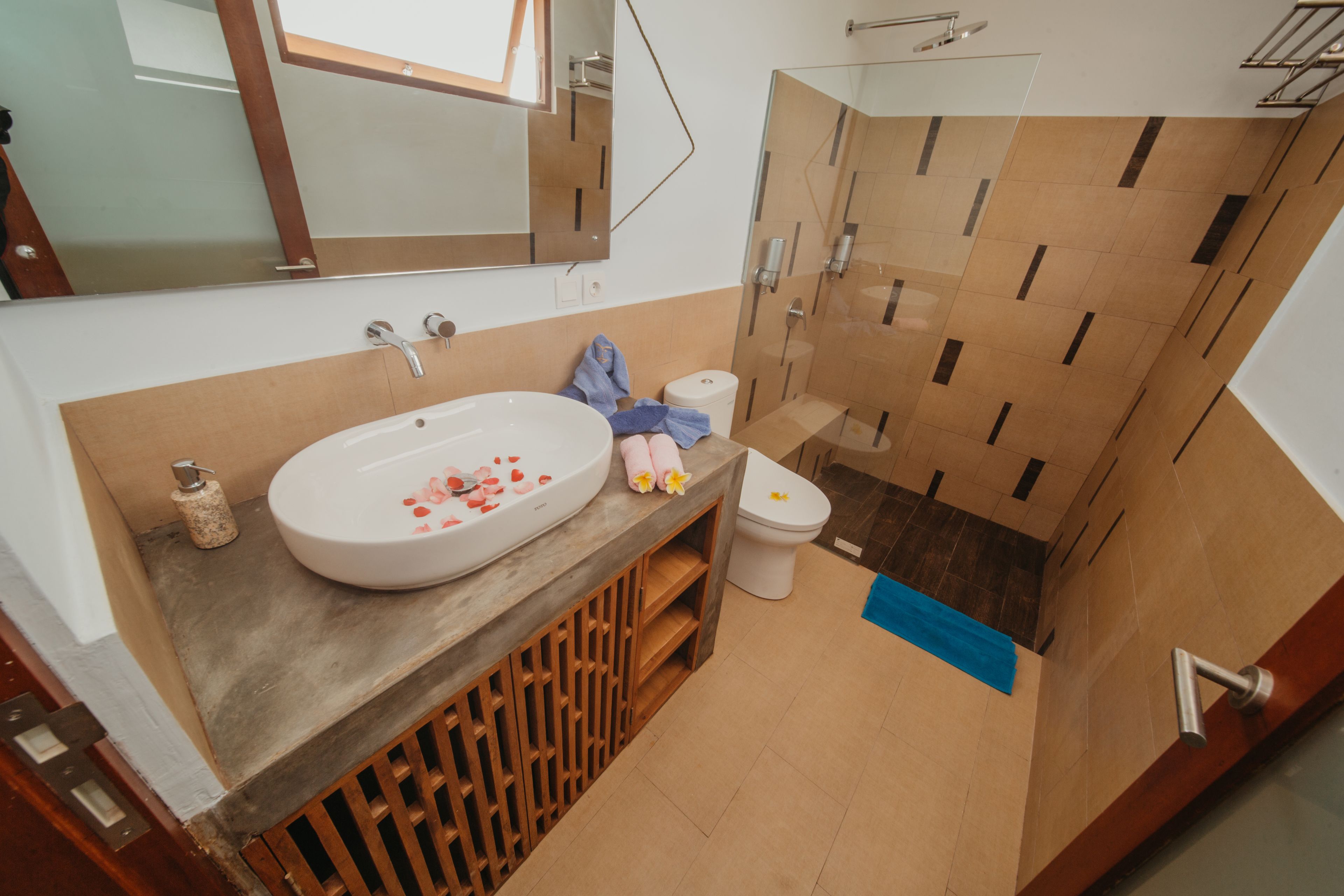 Een moderne badkamer met een groot wastafel, toilet en douchehoek.