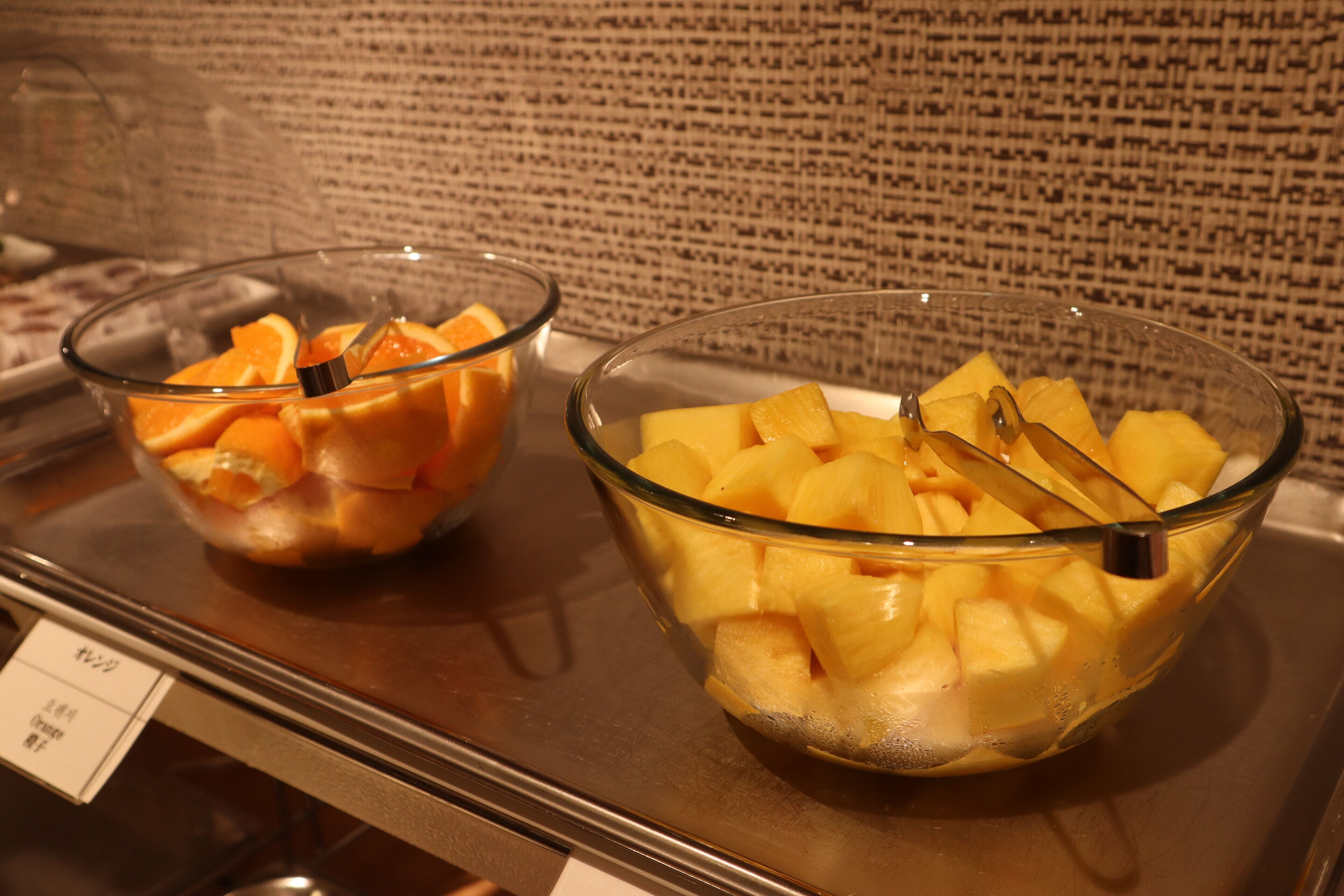 Two glass bowls containing fruit on a counter.