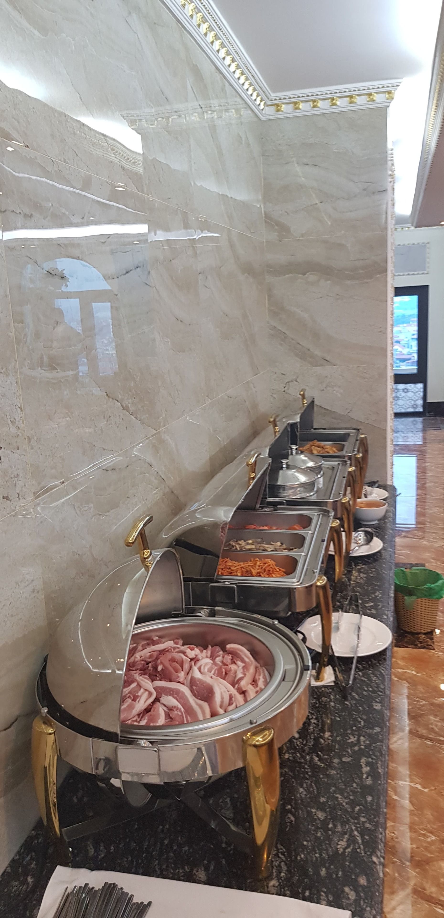 A buffet setup with various food items and a meat carving station.