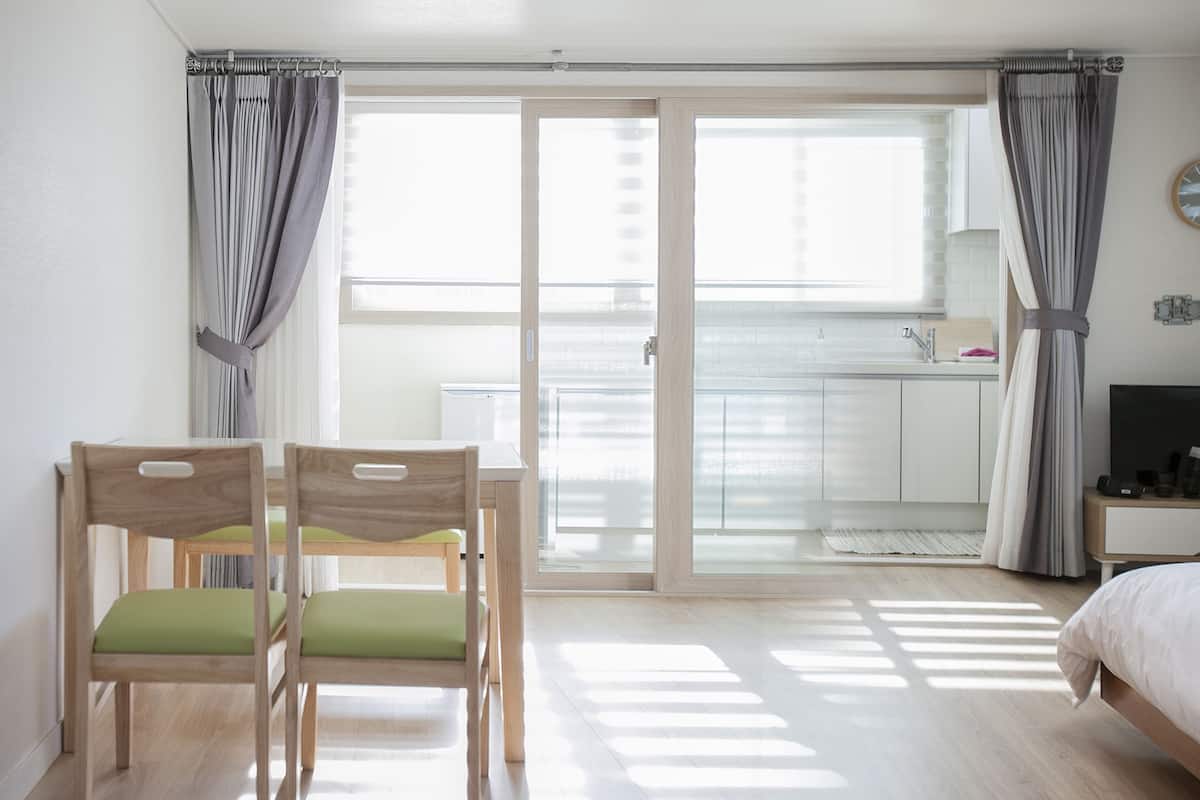 A bedroom with a bed, a desk, and a chair.