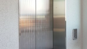 Un ascenseur moderne, doté d’une finition métallique et d’un écran numérique affichant le chiffre 1.