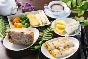 A table with various food items including bread, fruit, and a cup of coffee. - Beauty Spring and Harvest B and B (Puli)