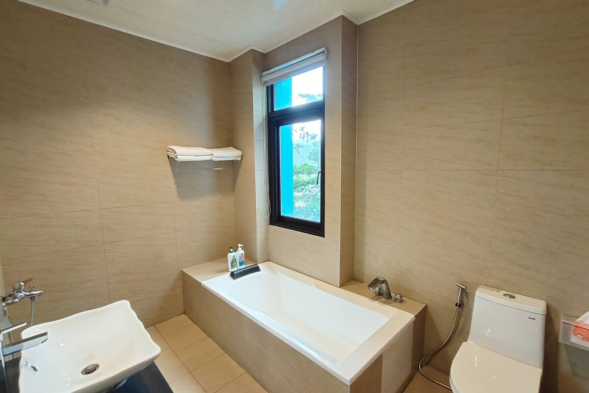 A modern bathroom with a bathtub, a sink, and a toilet.