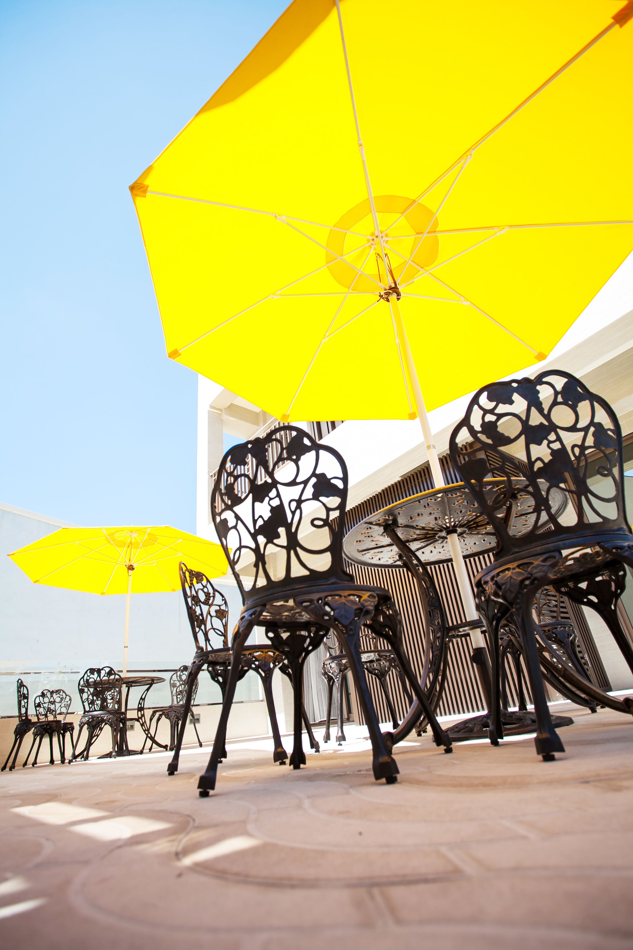Outdoor seating with yellow umbrellas and metal chairs.