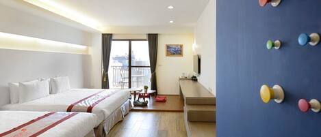 Habitación de hotel con dos camas, un escritorio, una silla, un televisor y ventana con vistas.