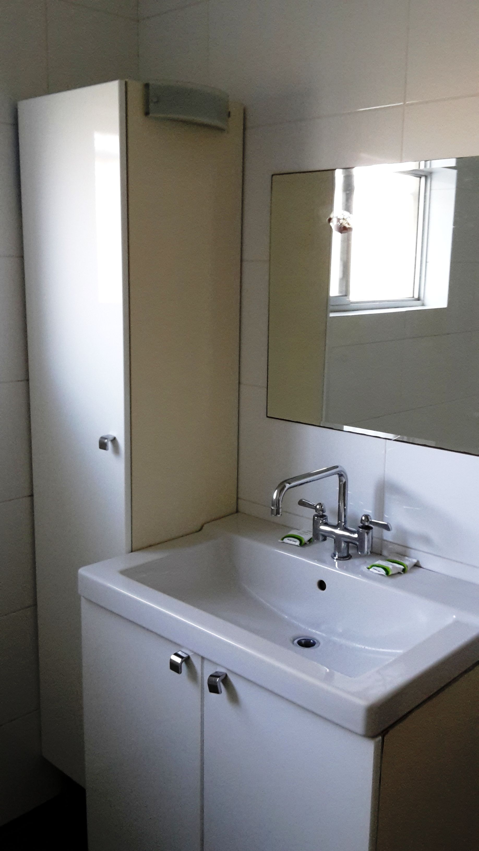 A bathroom with a white sink, a mirror, and a cabinet.