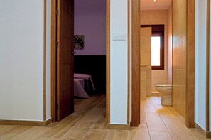Enter a simple, functional space with a bedroom and bathroom.