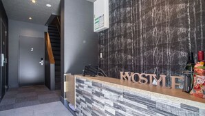 A reception desk with a modern design, a staircase, and a door labeled "2". - Japaning Kyoto (Kyoto)