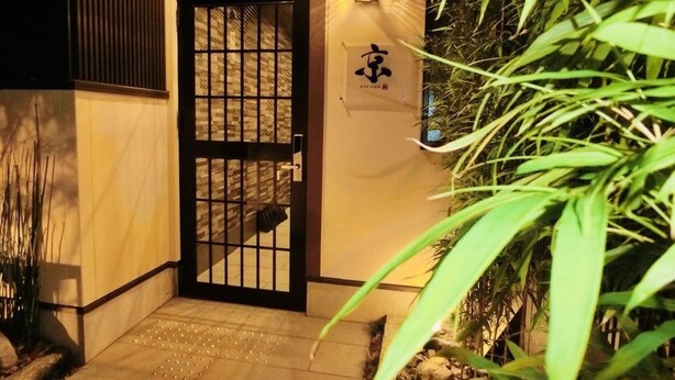 A traditional Japanese-style entrance with a sliding gate, a stone pathway, and a signboard with a logo. - Japaning Kyoto (Kyoto)