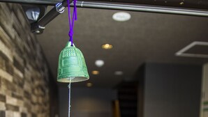 A hallway with a hanging green bell and a sign with Japanese characters. - Japaning Kyoto (Kyoto)