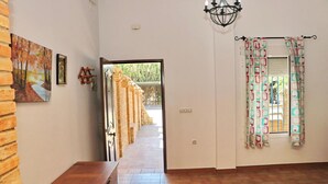 A hallway with a wooden bench, a door leading outside, and a window with patterned curtains. - Villa with private pool and Wi-Fi (CONIL DE LA FRONTERA)