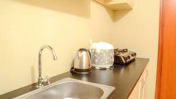 Apartamento, 3 quartos | Cozinha americana privada | Geladeira, micro-ondas, cooktop, chaleira elétrica