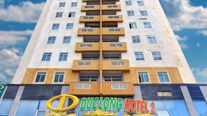 Un edificio alto de hotel con un letrero que dice 'DuocLong Hotel 2' y '70 Phong Tien Nghi'.