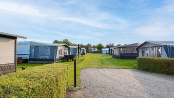 A caravan park with multiple caravans and a gravel path leading through the area.