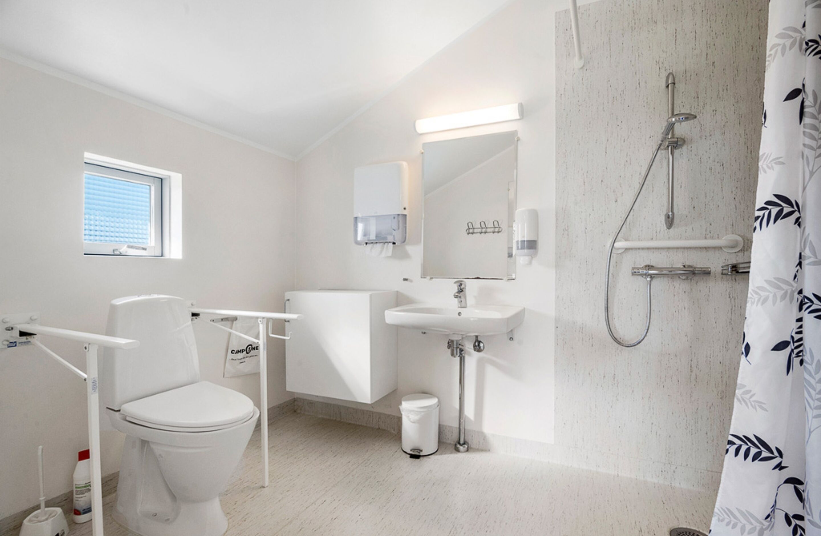 Un baño moderno con inodoro, lavamanos y ducha.