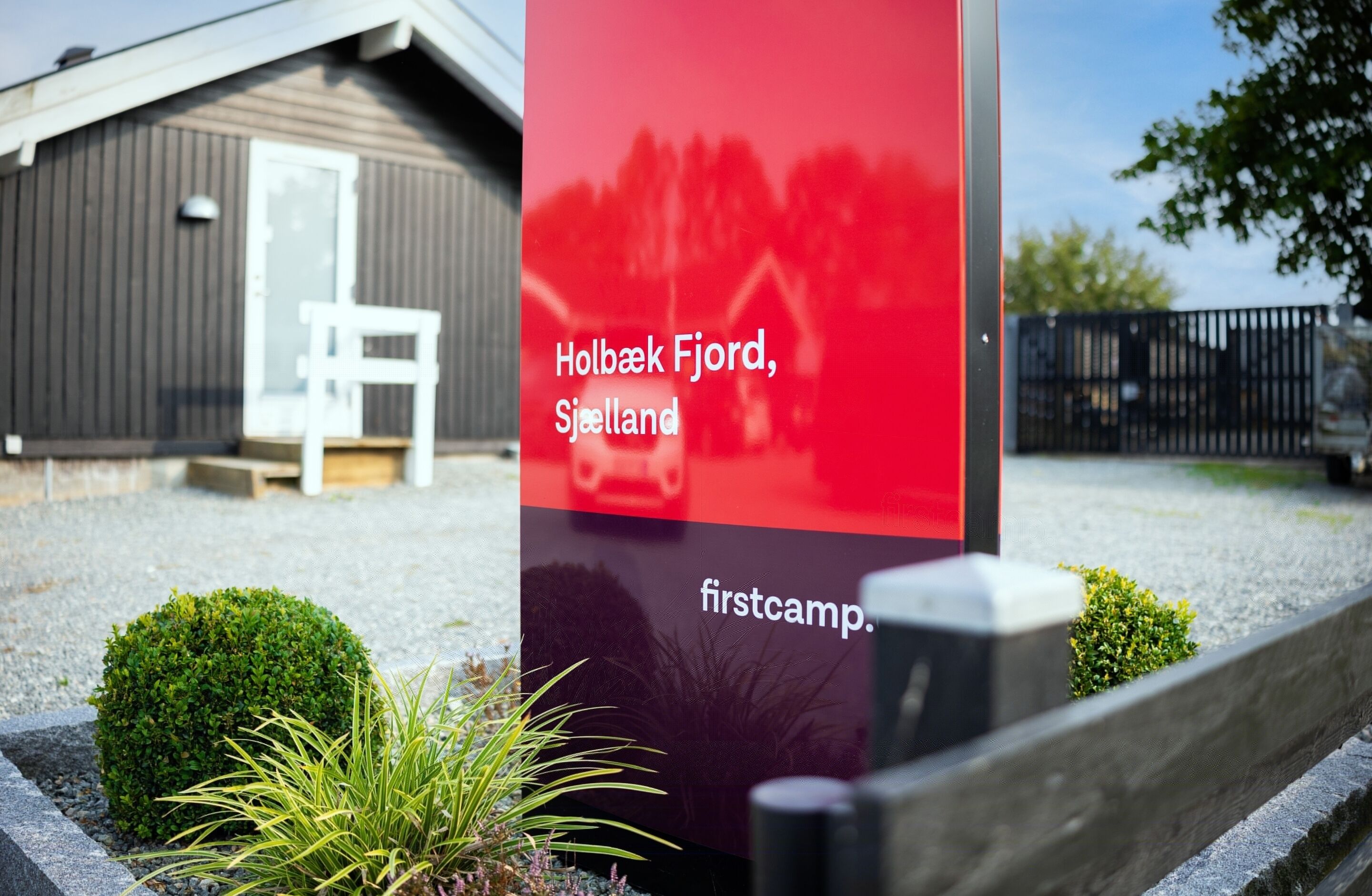 Segnaletica con la scritta 'Holbaek Fjord, Sjælland' e 'firstcamp', che indica un luogo e un campeggio.