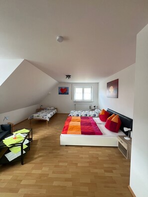Una camera da letto con un letto grande, una scrivania, una sedia, una finestra e una lampada a soffitto.