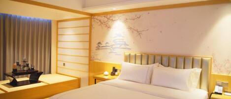 A hotel room with a large bed, a desk, and a nightstand.