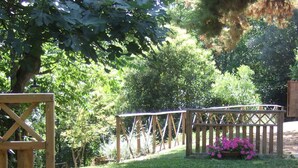 Un jardin avec une terrasse en bois, des plantes en pot et une clôture en bois.