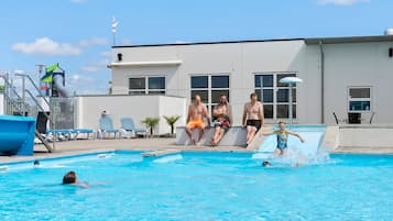 Guests can enjoy a refreshing swim in the pool surrounded by lounge chairs and a nearby building.