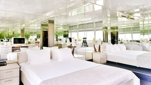 A modern hotel room with a large bed, bedside tables, a desk, and a television. - Terra Nova Sport & Spa Hotel (Hatne)