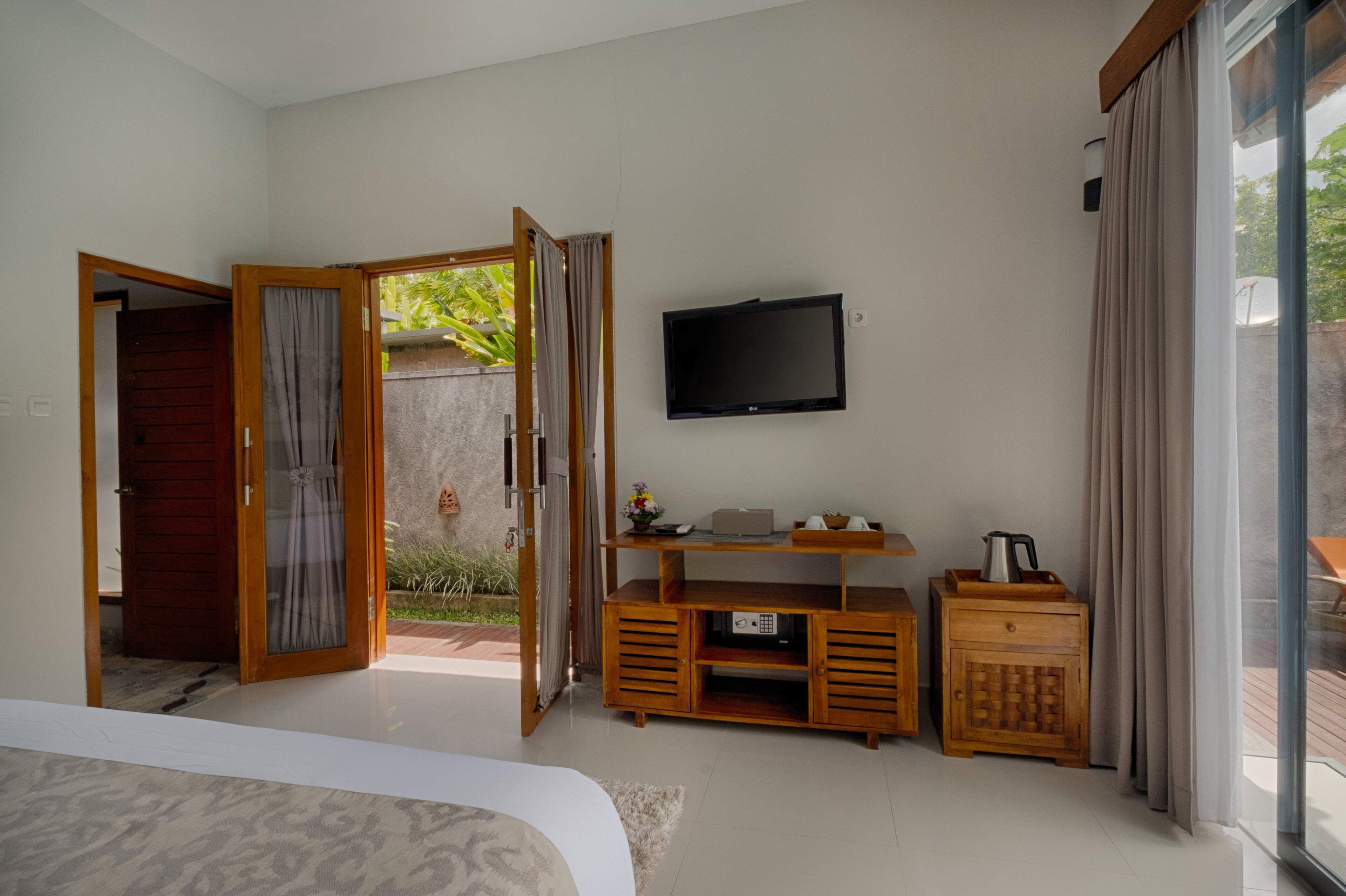 Un dormitorio con televisión, muebles de madera y vistas al exterior.