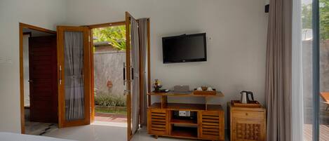Un dormitorio con televisión, muebles de madera y vistas al exterior.