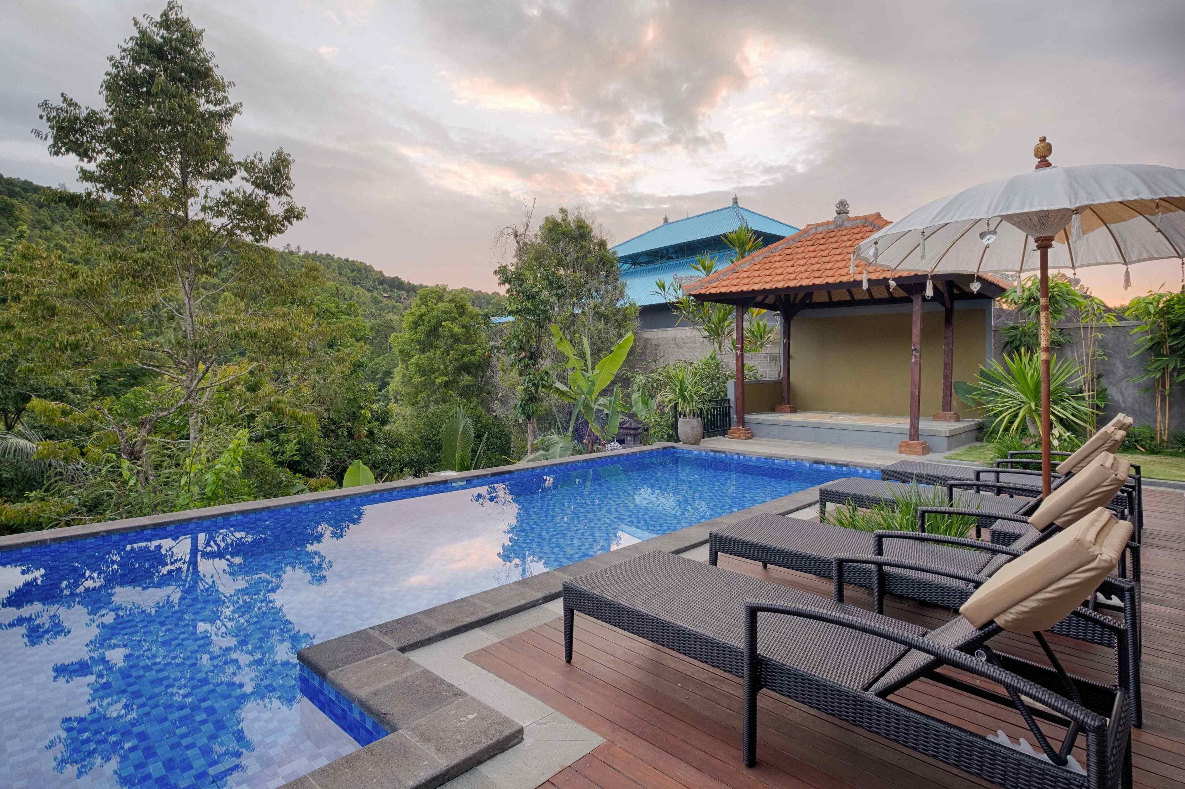 A swimming pool with lounge chairs and a gazebo.