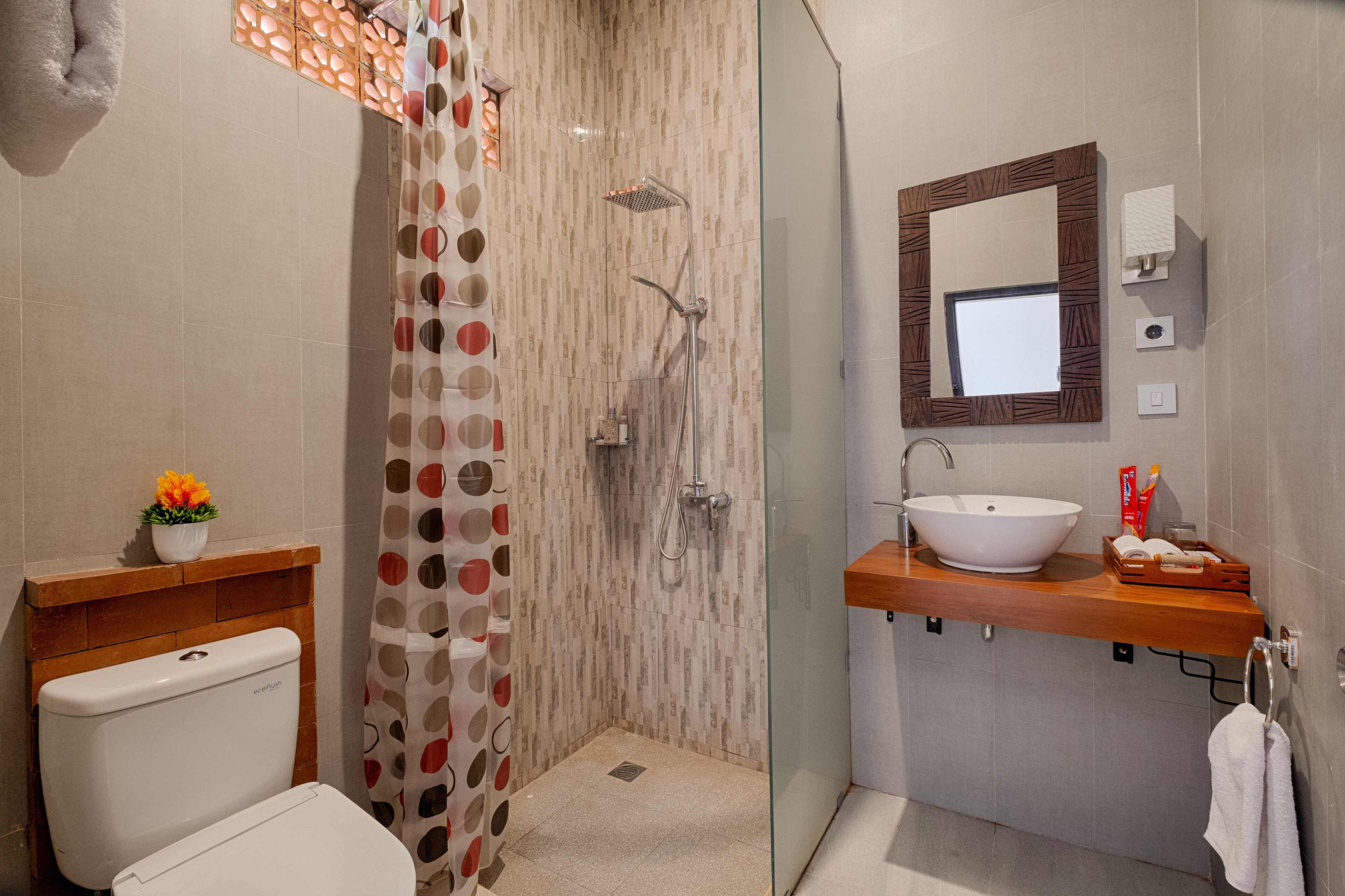 A modern bathroom with a shower, toilet, and sink.