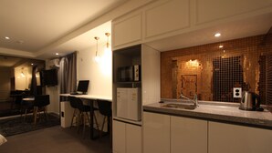 A modern kitchen with white cabinets, a built-in microwave, and a stainless steel sink.
