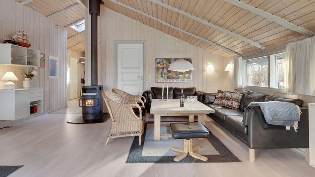 A cozy living room with a fireplace, a dining area, and a sofa. - Gorgeous home in Dronningmølle (Dronningmølle)