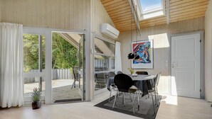 A modern interior with a dining area, large windows, and a view of the outdoors. - Gorgeous home in Dronningmølle (Dronningmølle)