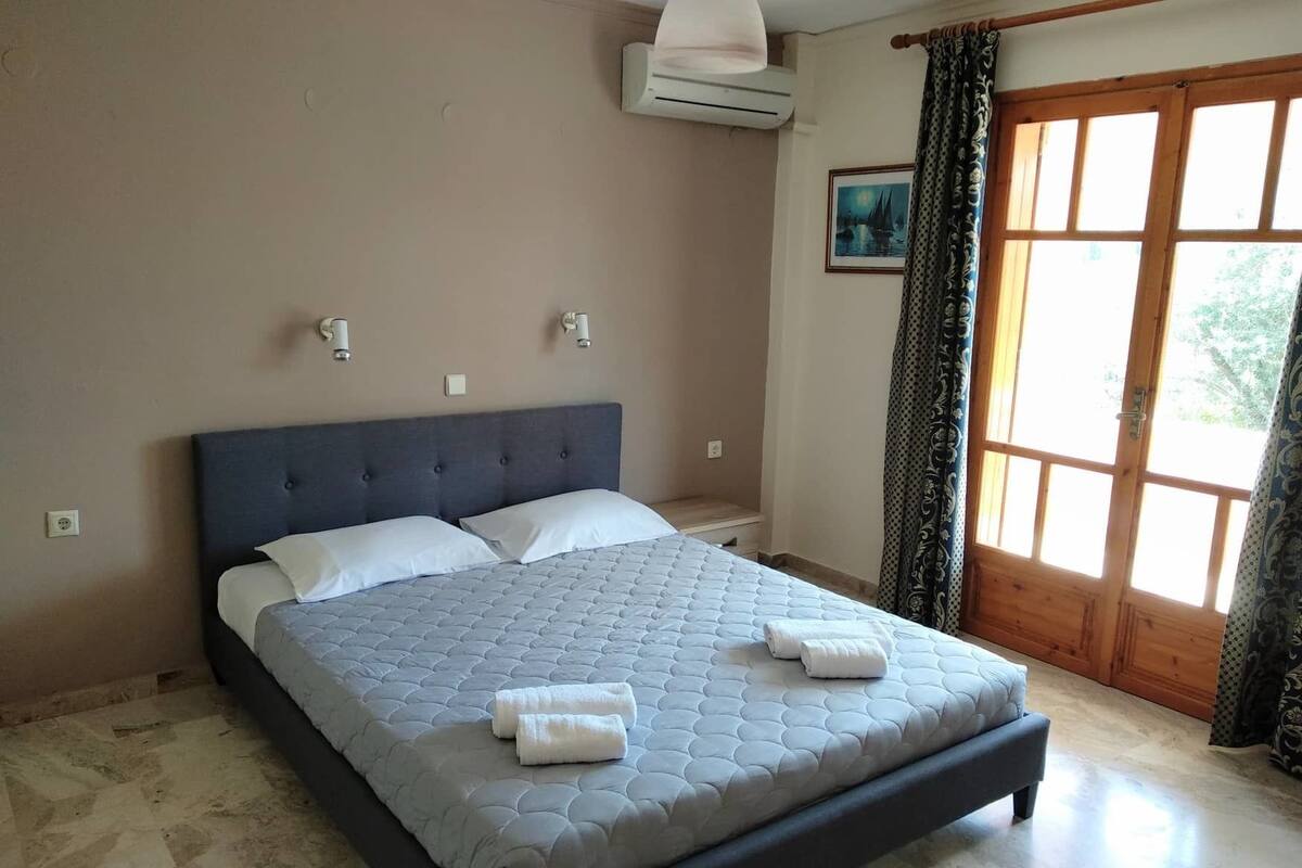 Ein Schlafzimmer mit einem Bett, einem Fenster und einer Tür.