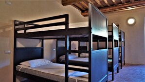 A room with bunk beds, wooden headboards, and a tiled floor. - Contessa Ava Dei Lambardi - Hostel (Monteriggioni)