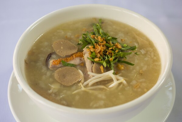 A bowl of soup with meat, noodles, and garnishes. - Natural House (Siem Reap)