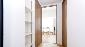 A hallway with wooden flooring leading to a room with a dining table and chairs. - OH Inn -Fukuoka Stay- (Fukuoka)