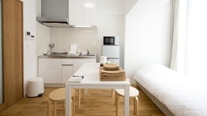 A compact, modern room with a kitchenette, a dining area, and a bed. - OH Inn -Fukuoka Stay- (Fukuoka)
