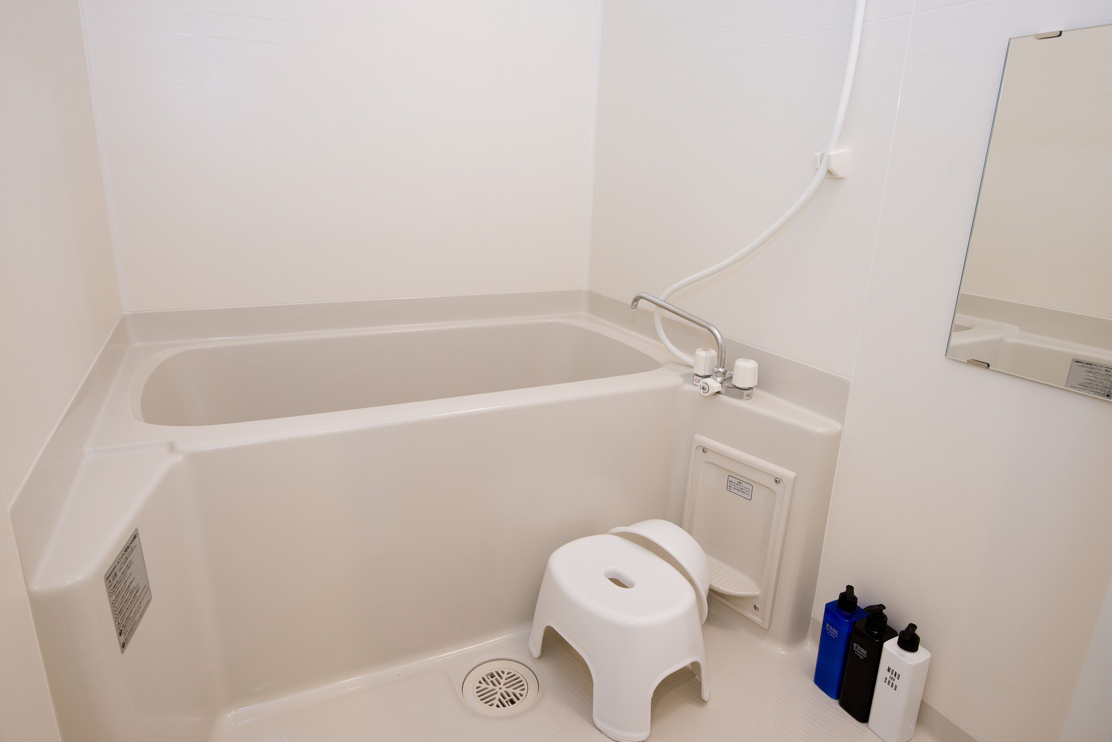 A small bathroom with a bathtub, a toilet, and a shower.