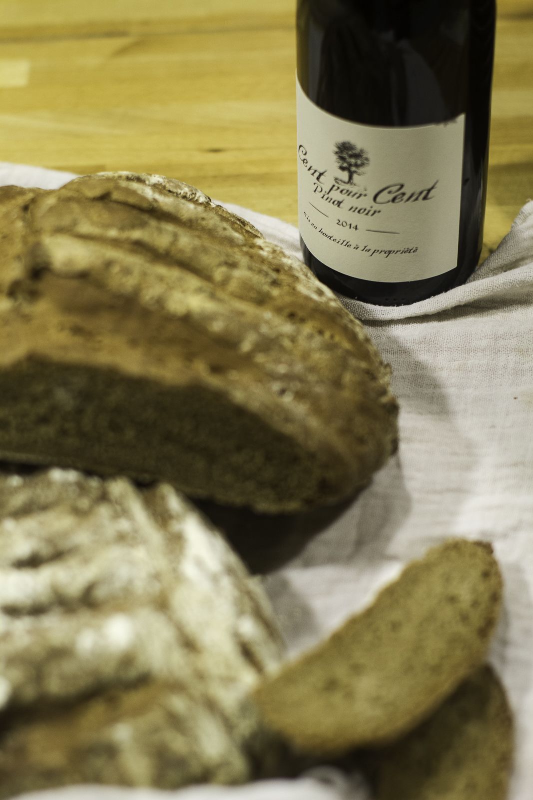 Een brood en een fles wijn op een doek.